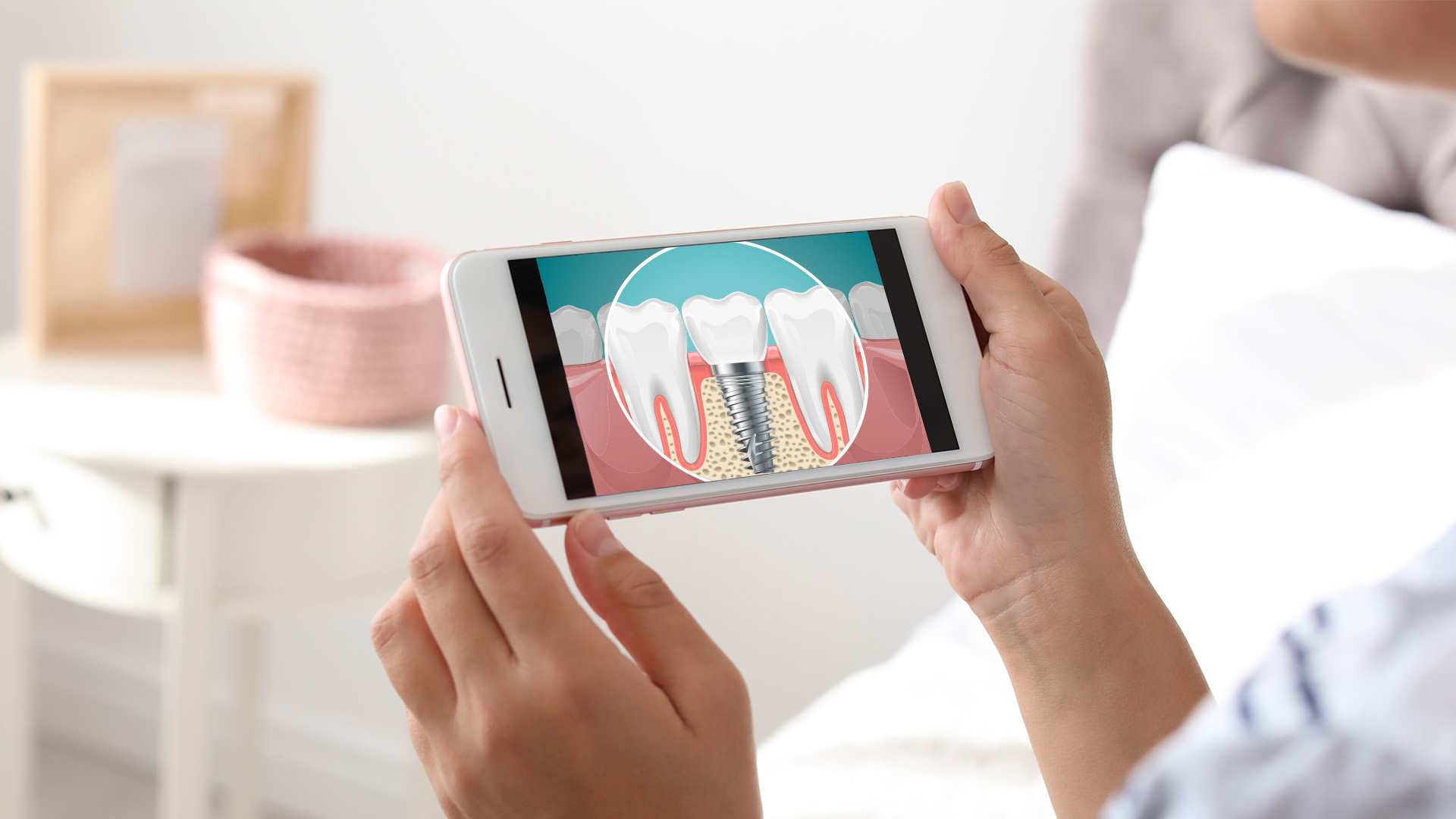 The image shows a person holding a smartphone displaying an illustration of a tooth with a cavity being filled, indicating dental care or dental health education.