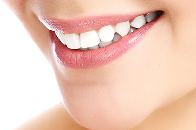 The image shows a close-up of a person s smiling face with a focus on their teeth and lips, highlighting dental care or cosmetic dentistry services.