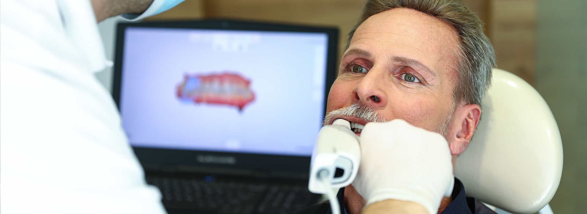 A man receiving dental treatment with a dental hygienist performing the procedure.