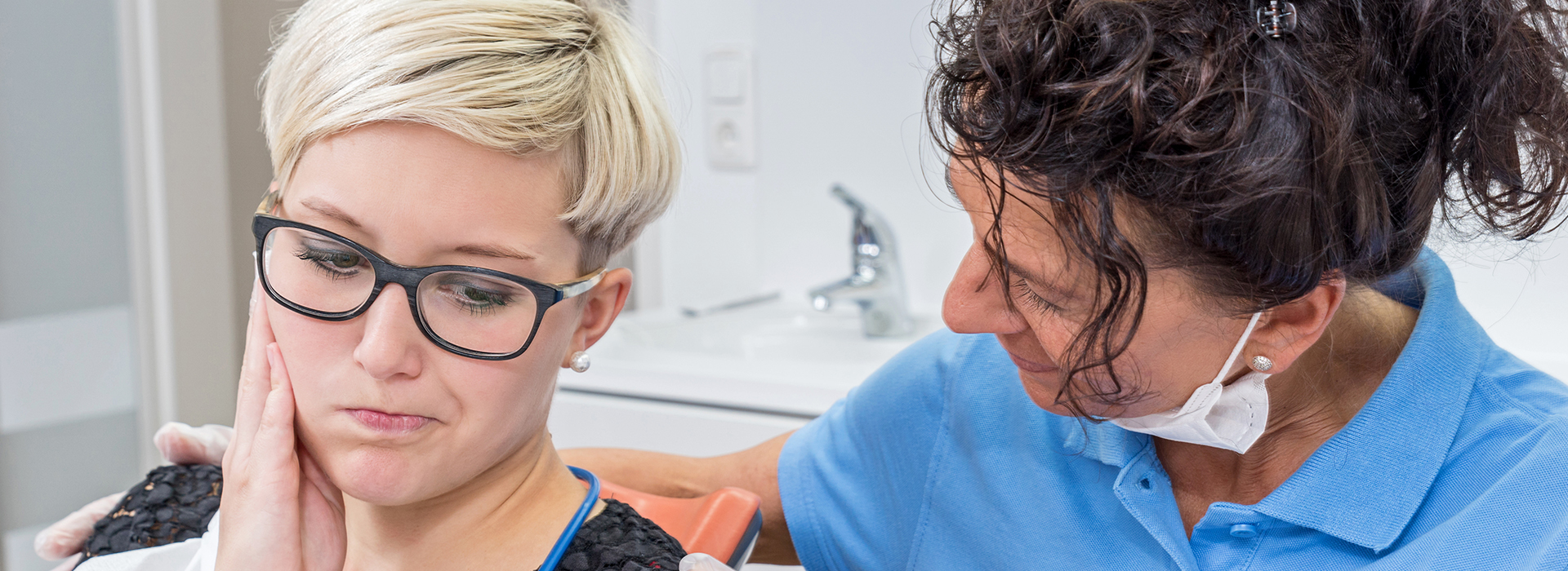 The image shows two individuals in a dental setting  on the left, there s a person with glasses holding a device, possibly for oral care, while on the right, another individual appears to be performing a dental procedure.