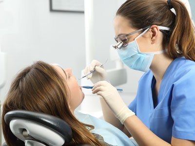 Dental hygienist assisting patient with dental treatment.